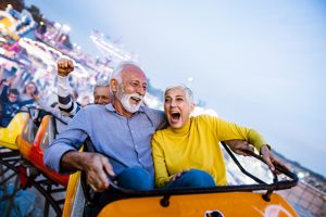 Cheerful mature couple having fun on a roller coaster.
